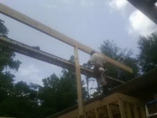 Carpenter setting a ridge beam over a new addition frame — Ice Dam Removal by Roofing Brothers in Roca