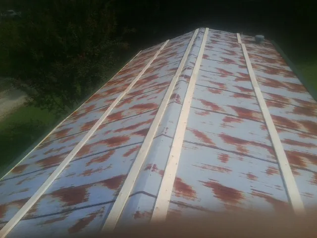 Rusted metal roof panels with new wood purlins before replacement — Storm Damage Roof Repair in Roca by Roofing Brothers